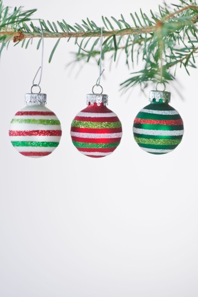 Studio shot of striped Christmas ornaments hanging on Christmas tree. Photo : Daniel Grill