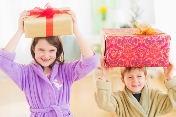 Girl (8-9) and boy (6-7) carrying christmas gifts on their heads. Photo : Daniel Grill