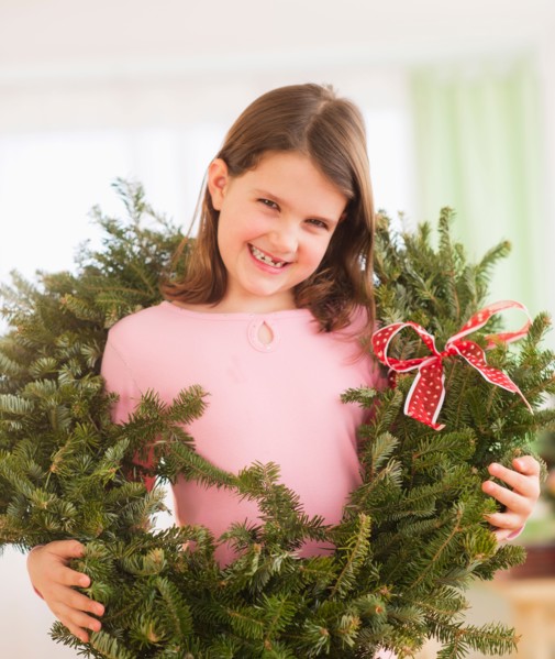 Portrait of girl (8-9) with christmas wreath. Photo : Daniel Grill