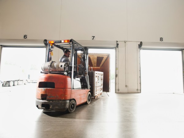 Forklift driver working in warehouse.