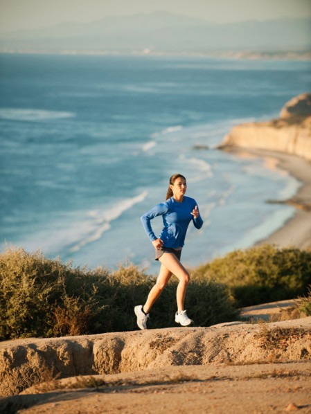 USA, California, San Diego, Woman jogging along sea coast.