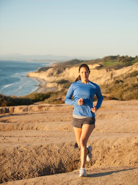 USA, California, San Diego, Woman jogging along sea coast.