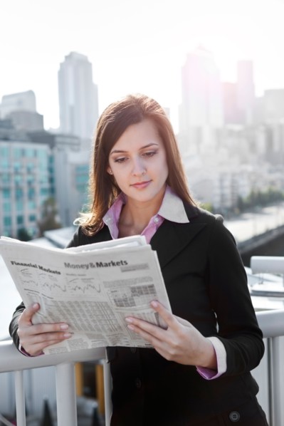 USA, Seattle, Young businesswoman reading newspaper. Photo : Take A Pix Media