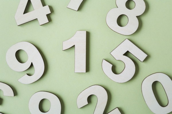 Numbers on white background, studio shot. Photo : Kristin Lee