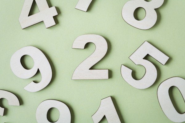 Numbers on white background, studio shot. Photo : Kristin Lee