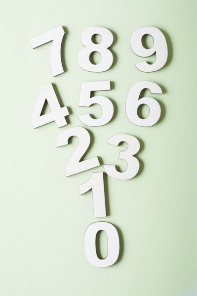 Numbers on white background, studio shot. Photo : Kristin Lee