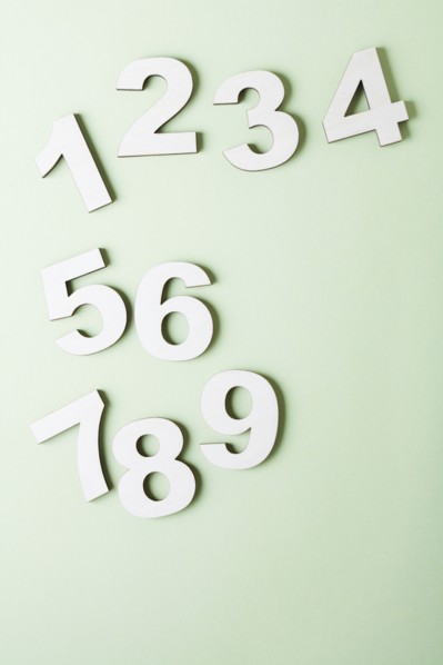 Numbers on white background, studio shot. Photo : Kristin Lee