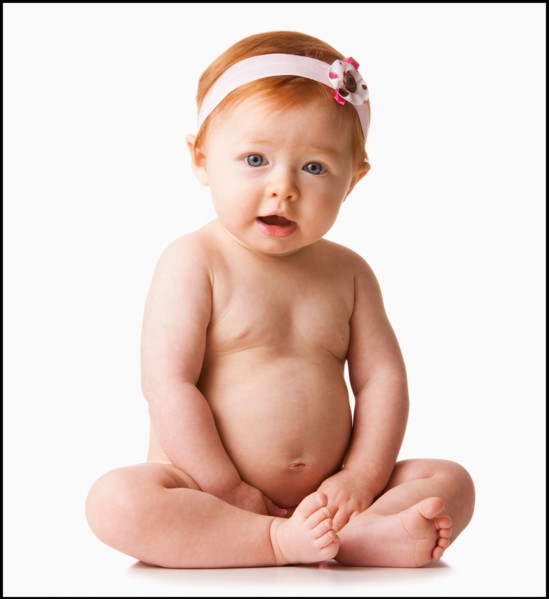 Portrait of baby girl (6-11 months) smiling, studio shot. Photo : Mike Kemp