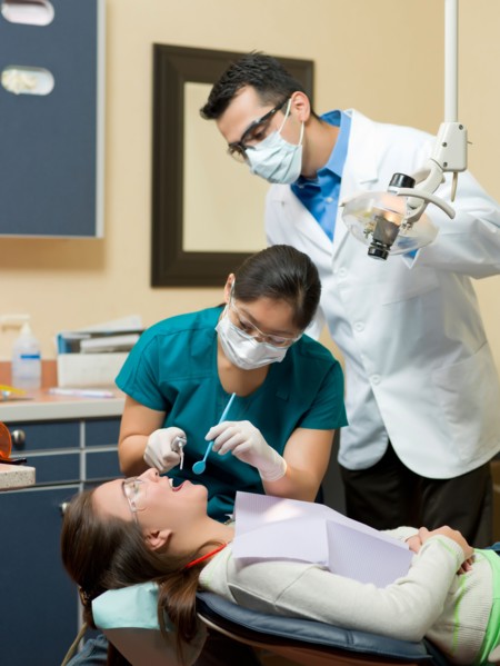 Dentists and patient in dental surgery. Photo : Dan Bannister