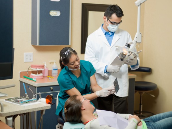 Dentists and patient in dental surgery. Photo : Dan Bannister