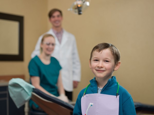 Portrait of patient, dentists in background. Photo : Dan Bannister
