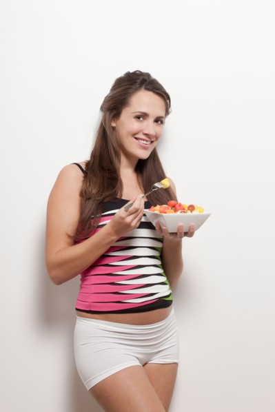 Portrait of pregnant woman holding bowl with salad, studio shot. Photo : Jan Scherders