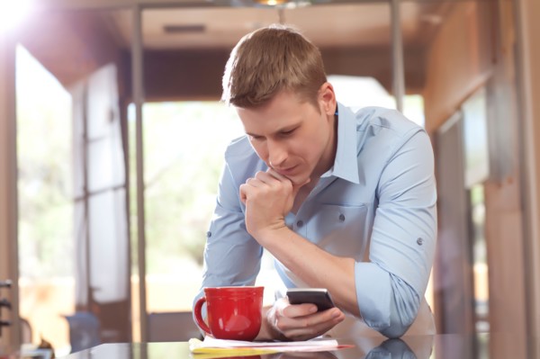 Man texting at home. Photo : db2stock