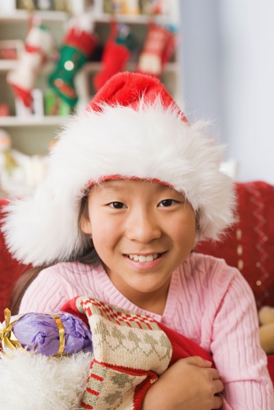 Portrait of teenage Girl (10-11) wearing santa hat. Photo : Rob Lewine