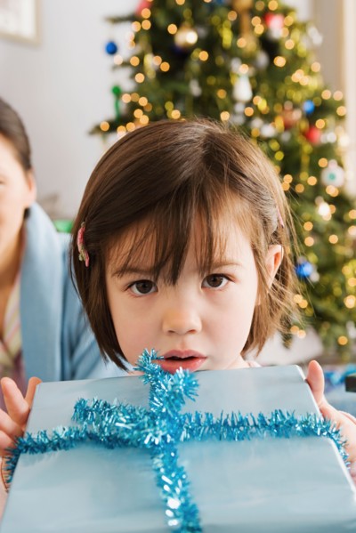 Girl holding christmas present. Photo : Rob Lewine