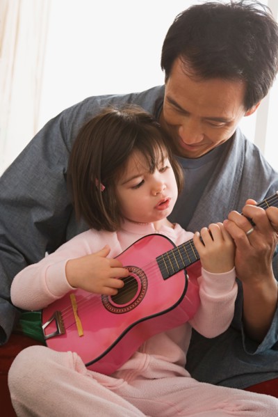 Father and daughter playing guitar. Photo : Rob Lewine