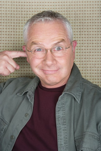 Older man putting finger in ear. Photo : Rob Lewine