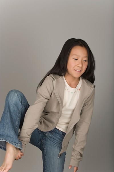 Studio portrait of teen (16-17) girl standing on one leg. Photo : Rob Lewine