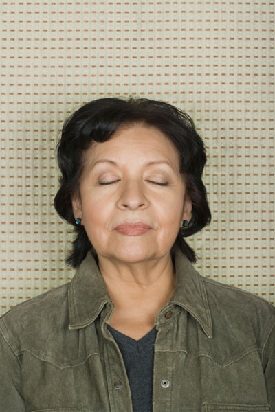 Studio portrait of senior woman with eyes closed. Photo : Rob Lewine