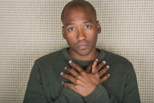 Studio portrait of mid adult man with hands folded on chest. Photo : Rob Lewine