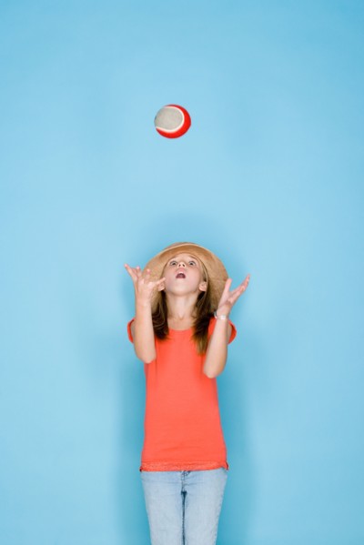 Studio shot portrait of teenage girl throwing ball, three quarter length. Photo : Rob Lewine