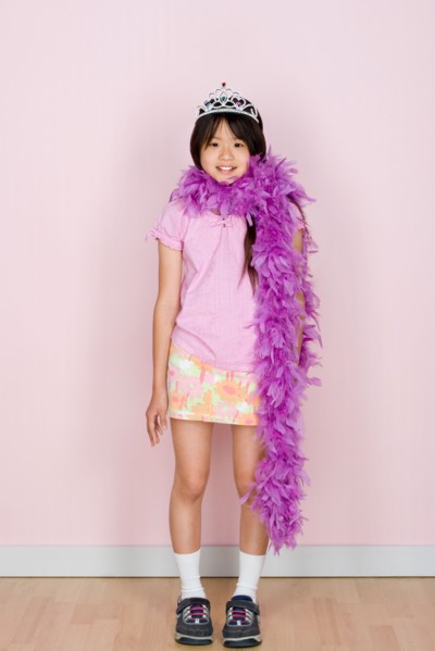 Studio shot portrait of teenage girl in diadem and feather boa shawl, full length. Photo : Rob
