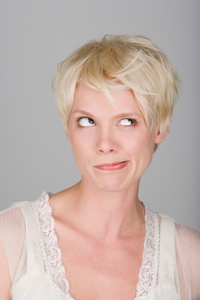Studio shot portrait of mid adult woman blowing hair over face, close-up. Photo : Rob Lewine