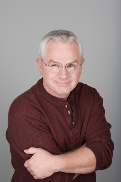 Studio shot portrait of senior man with arms crossed, head and shoulders. Photo : Rob Lewine