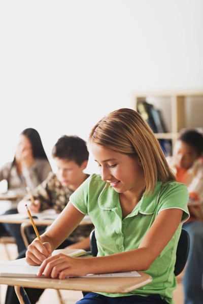 School kid writing in their copybooks. Photo : Rob Lewine
