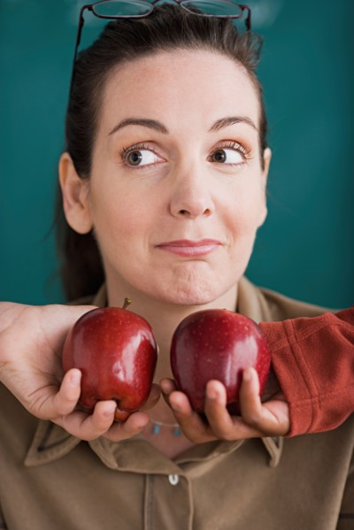 Teacher being offered tow apples by pupils. Photo : Rob Lewine