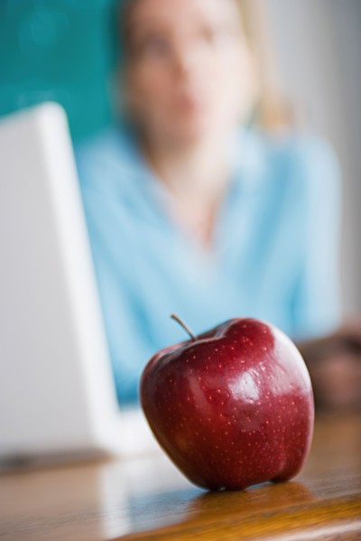 Woman with apple and laptop. Photo : Rob Lewine