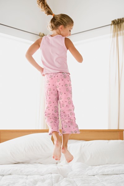 Girl jumping on bed. Photo : Rob Lewine