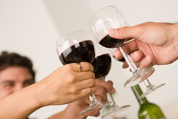 Hands holding wineglasses during toast . Photo : Rob Lewine