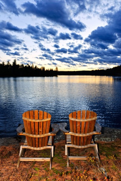 Canada, Ontario, Algonquin Park, Adirondack chairs on edge of lake. Photo :  Elena Elisseeva