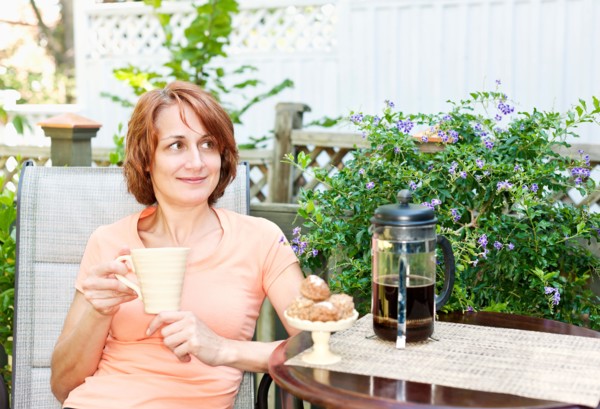 Woman having coffee in garden. Photo : Elena Elisseeva