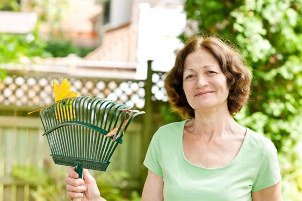 Senior woman with rake in garden. Photo : Elena Elisseeva
