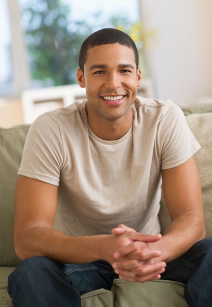 Portrait of man sitting on sofa.