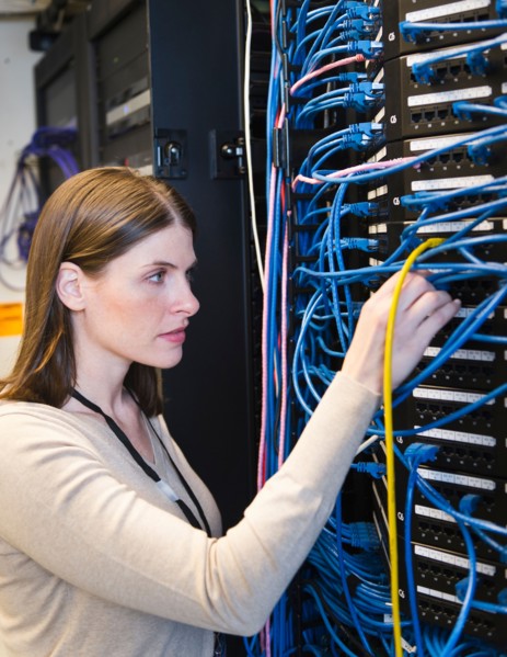 Female IT support technician repairing server.