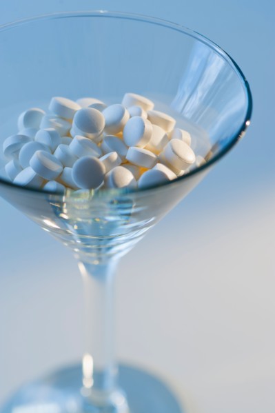 Martini glass filled with pills, studio shot.