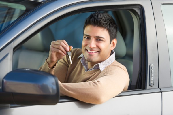 Man sitting in his new car.