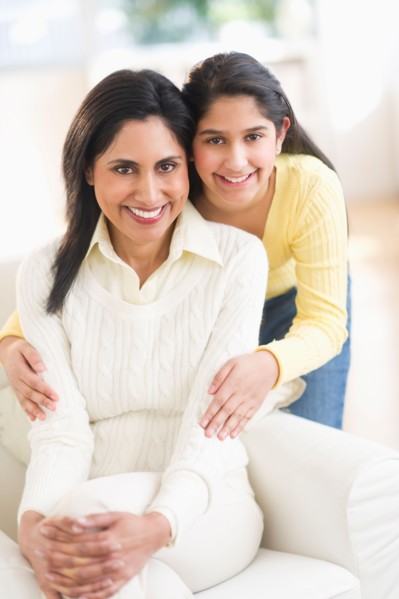 Portrait of mother and daughter (12-13) at home.