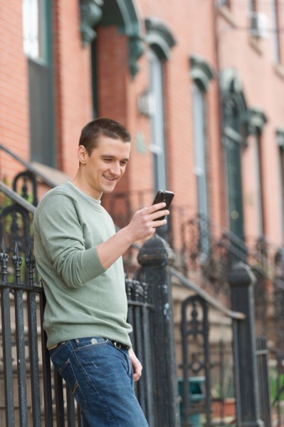 Man using smart phone on street.