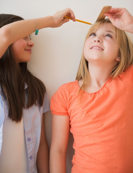 Two girls measuring height. Photo : Jamie Grill
