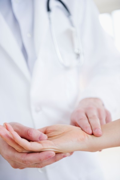 Close up of doctor taking patient's pulse. Photo : Jamie Grill