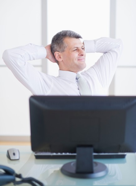 Portrait of businessman relaxing at desk. Photo : Daniel Grill