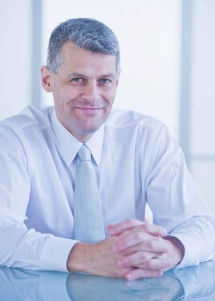 Portrait of businessman sitting at desk. Photo : Daniel Grill