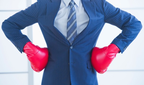 Businessman wearing red boxing gloves. Photo : Daniel Grill