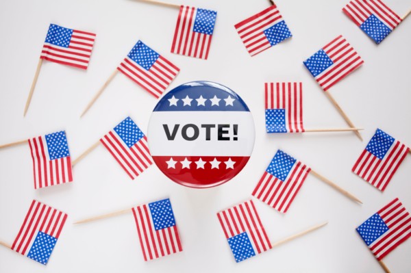 Studio shot of vote pin and small american flags. Photo : Winslow Productions