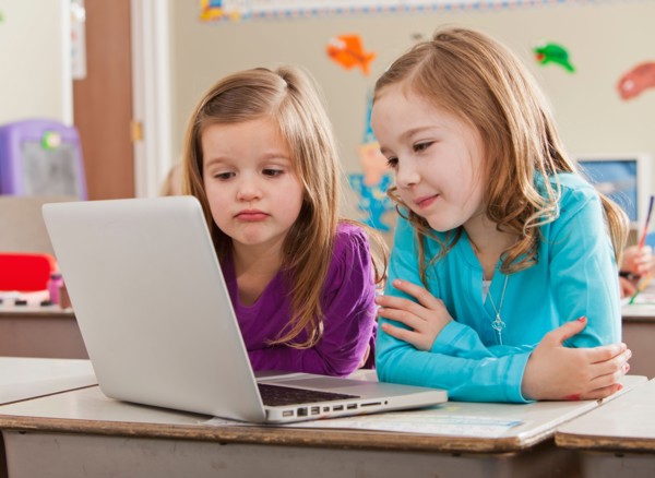 Children (4-5, 6-7) at school using laptop. Photo : Mike Kemp