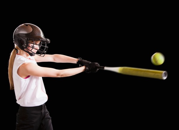 Girl (12-13) plying softball, studio shot. Photo : Mike Kemp